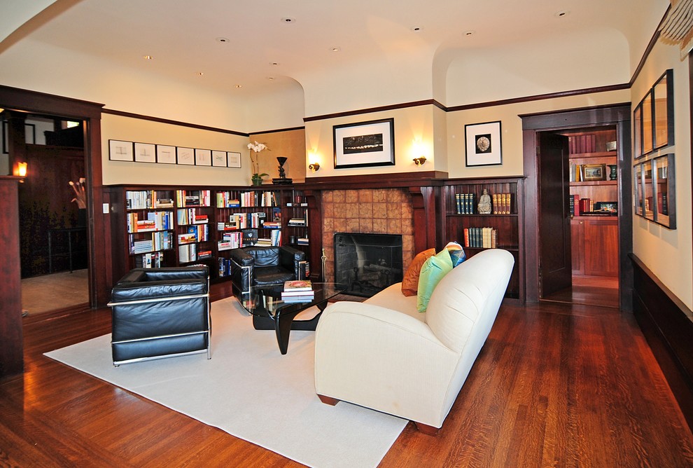 Photo of a mid-sized arts and crafts home office in San Francisco with beige walls, a standard fireplace, a tile fireplace surround, dark hardwood floors, a library and brown floor.