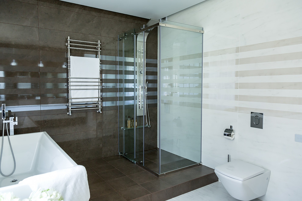 Inspiration for a mid-sized contemporary master bathroom in Novosibirsk with flat-panel cabinets, white cabinets, a freestanding tub, a curbless shower, a wall-mount toilet, brown tile, ceramic tile, beige walls, porcelain floors, a drop-in sink, granite benchtops, beige floor, a hinged shower door and white benchtops.