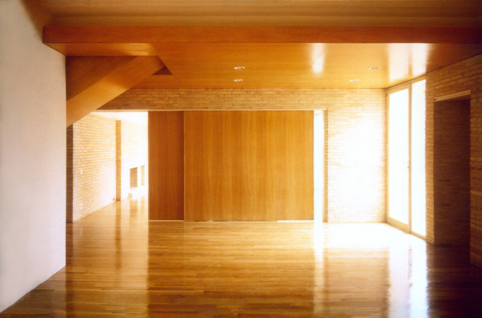 Immagine di una grande sala da pranzo aperta verso il soggiorno tradizionale con pavimento in legno massello medio, camino classico, cornice del camino in mattoni e pareti in mattoni