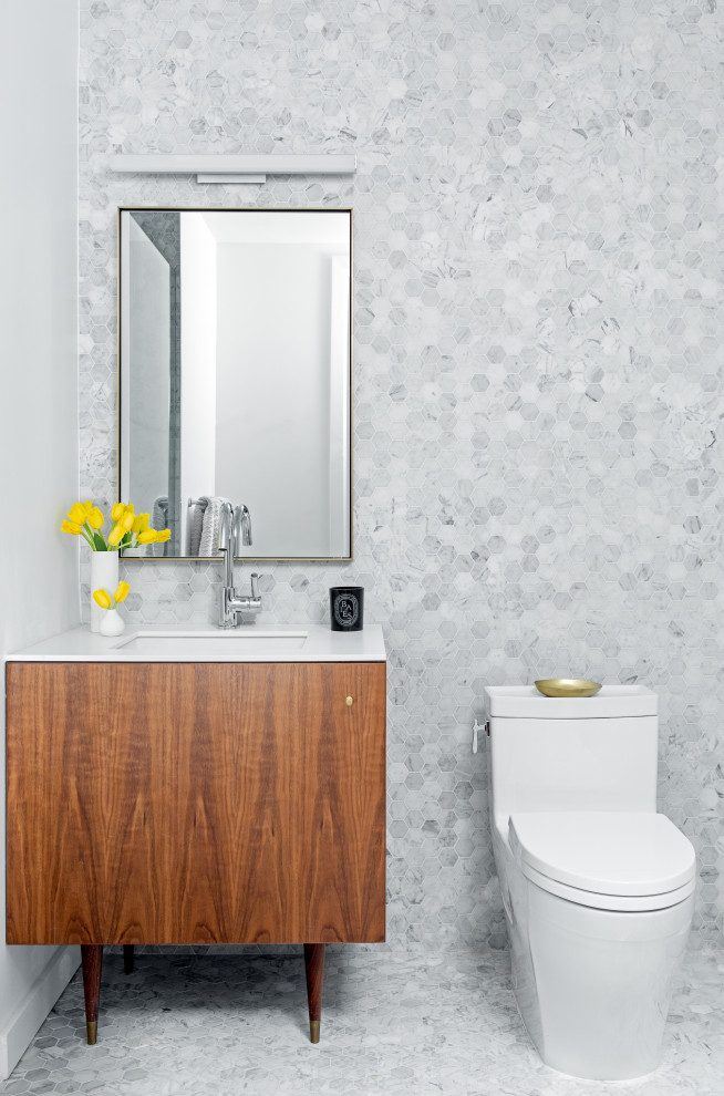 Trendy gray tile and marble tile mosaic tile floor, gray floor and single-sink bathroom photo in New York with flat-panel cabinets, medium tone wood cabinets, an undermount sink, quartz countertops, white countertops, a freestanding vanity, a one-piece toilet and gray walls