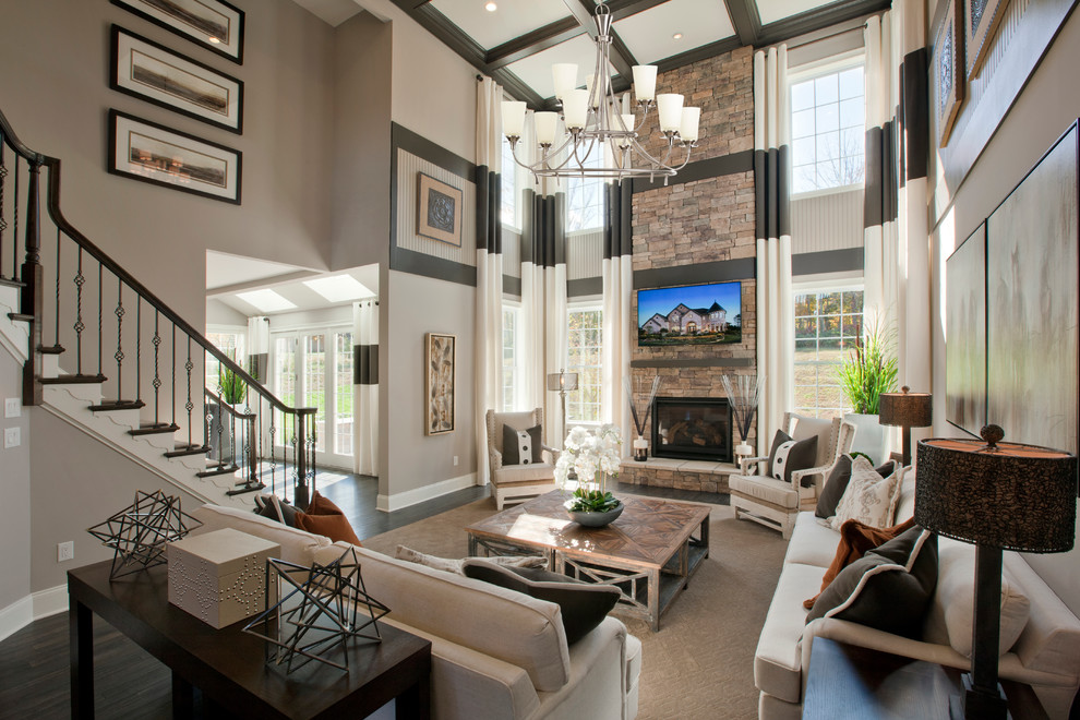 Photo of an expansive transitional open concept family room in Philadelphia with beige walls, dark hardwood floors, a standard fireplace, a stone fireplace surround and a wall-mounted tv.