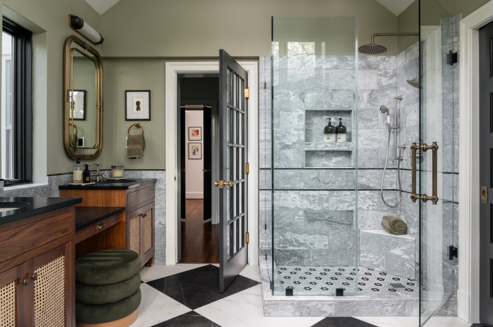 Example of a mid-sized transitional master green tile and marble tile marble floor, double-sink and vaulted ceiling freestanding bathtub design in DC Metro with louvered cabinets, medium tone wood cabinets, green walls, an undermount sink, marble countertops, a hinged shower door, black countertops and a built-in vanity