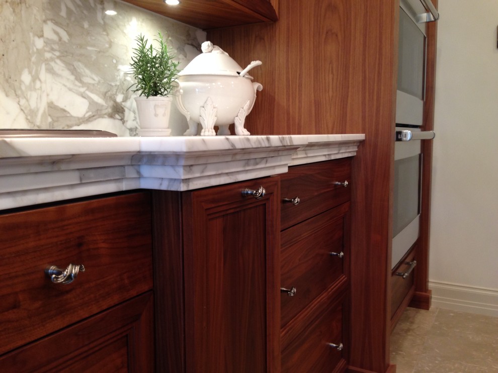 Eat-in kitchen - mid-sized transitional single-wall beige floor eat-in kitchen idea in Chicago with flat-panel cabinets, medium tone wood cabinets, marble countertops, white backsplash, marble backsplash, paneled appliances and an island