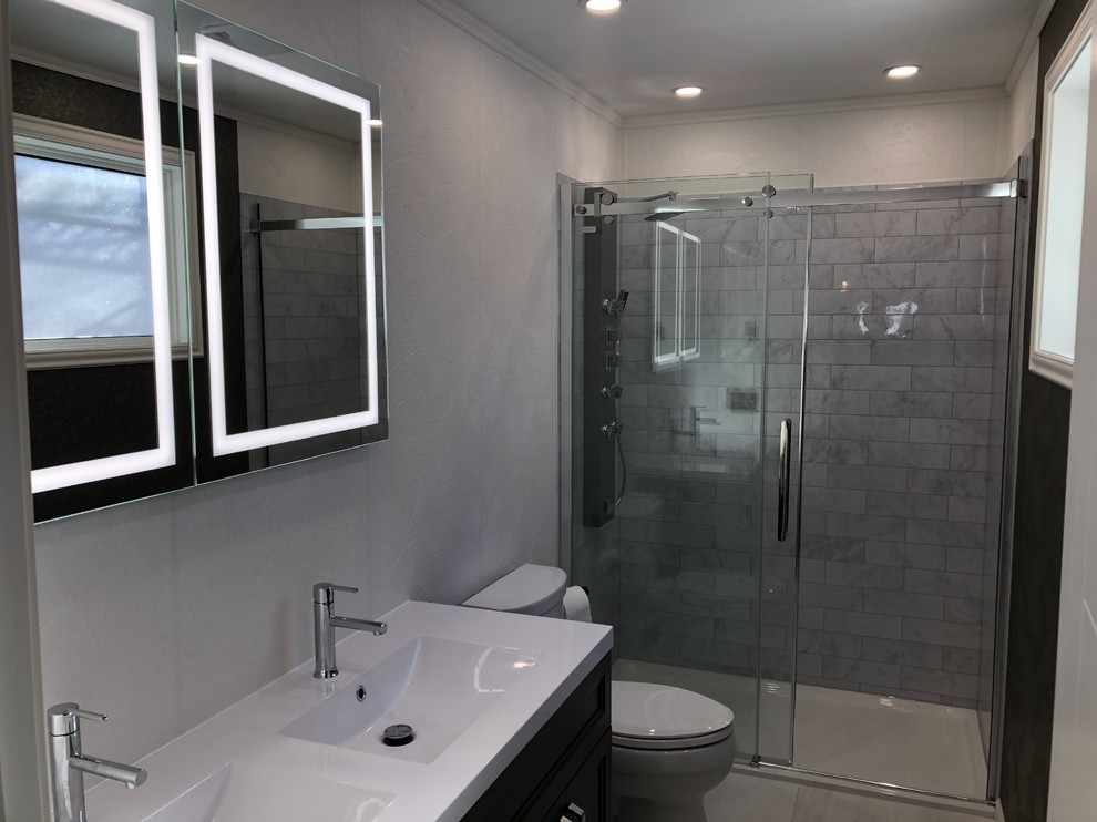 Design ideas for a mid-sized modern master bathroom in Other with furniture-like cabinets, brown cabinets, a double shower, a two-piece toilet, white tile, white walls, ceramic floors, an integrated sink, soapstone benchtops, white floor, a sliding shower screen and white benchtops.