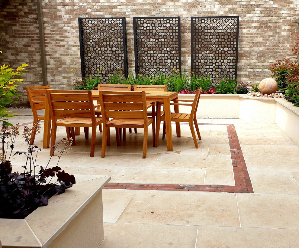 Contemporary courtyard partial sun formal garden in Cambridgeshire with natural stone pavers.