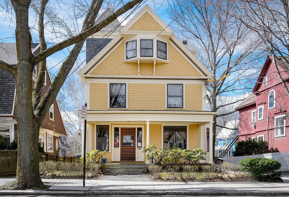 Traditional yellow exterior in Boston with wood siding.