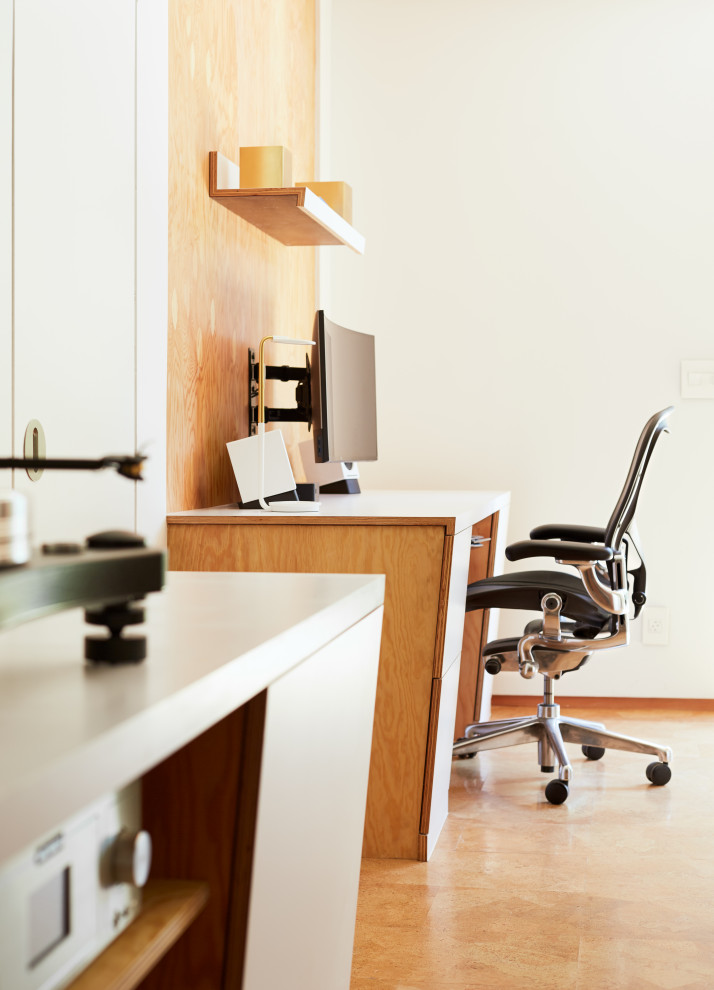 Cette image montre un petit bureau design en bois de type studio avec un sol en liège, un bureau intégré et un plafond voûté.