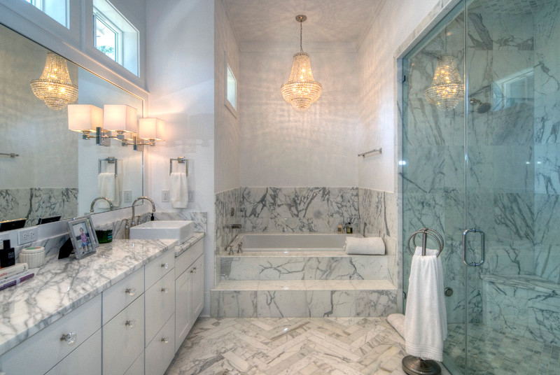 This is an example of a mid-sized beach style master bathroom in Miami with shaker cabinets, white cabinets, an alcove tub, a double shower, gray tile, marble, grey walls, marble floors, a vessel sink and marble benchtops.