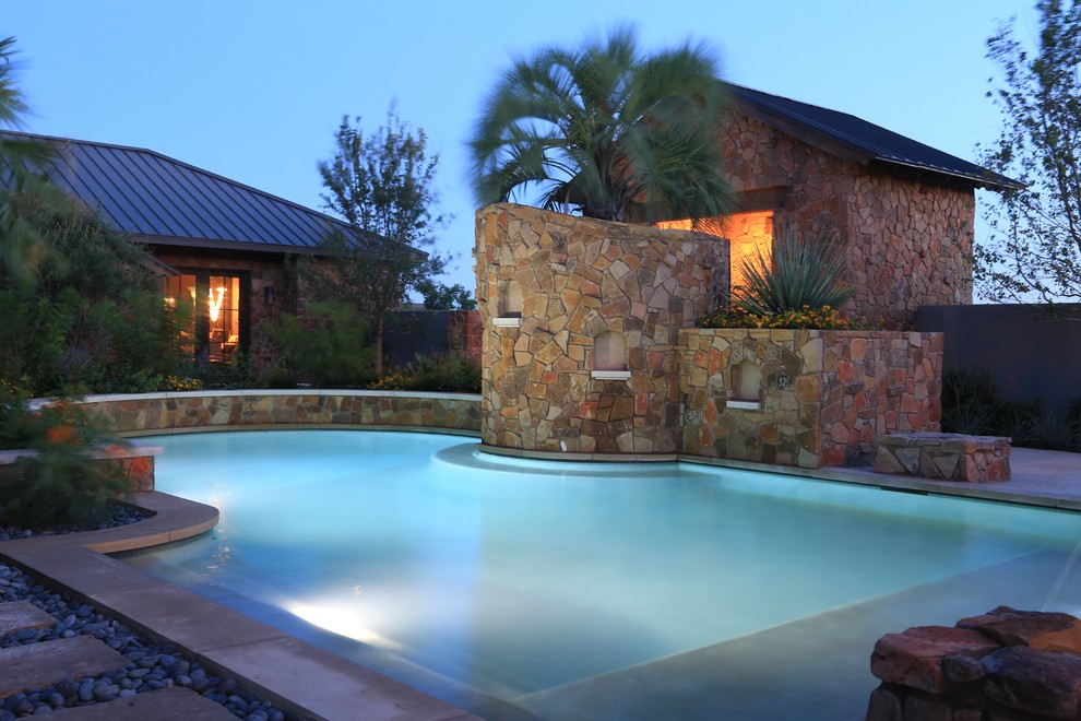 Inspiration for a large country backyard custom-shaped natural pool in Austin with a pool house and concrete pavers.