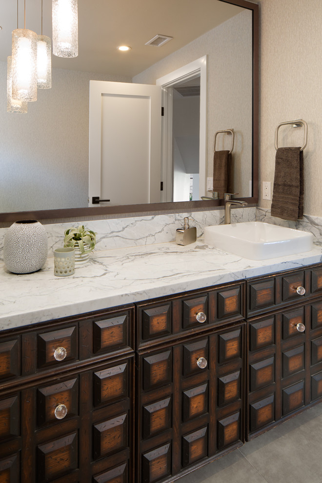 Mid-sized contemporary powder room in San Diego with an undermount sink, raised-panel cabinets, dark wood cabinets, marble benchtops, a two-piece toilet, beige tile and porcelain floors.