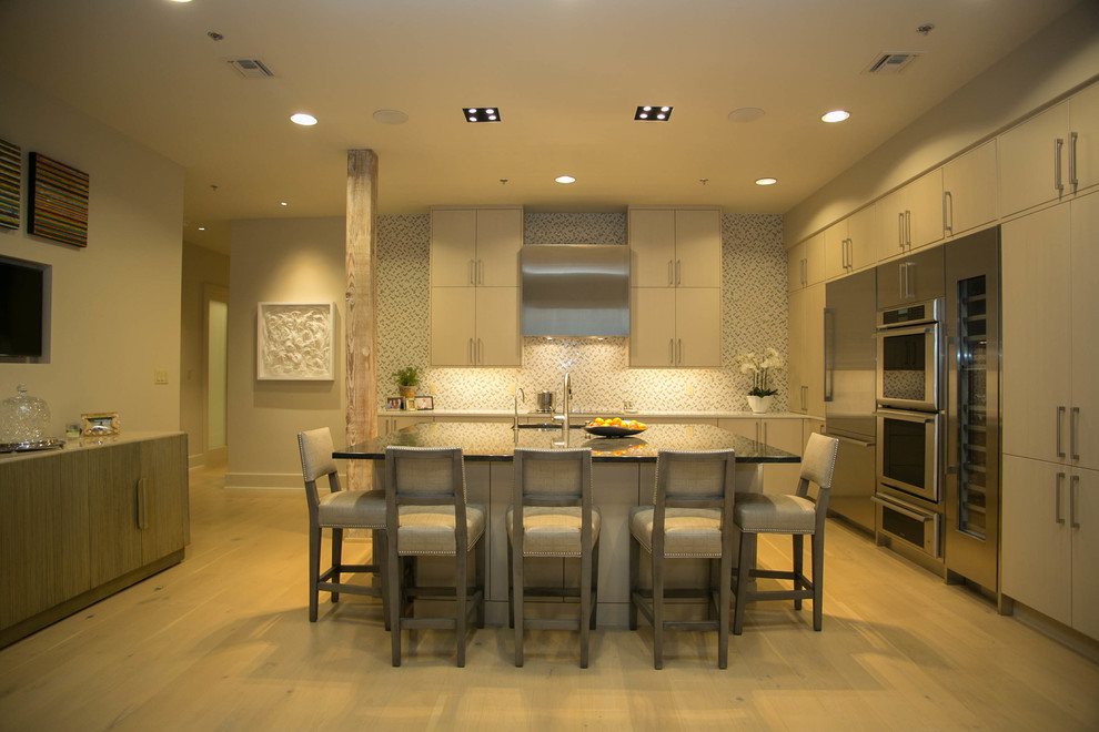 Mid-sized transitional l-shaped light wood floor kitchen photo in New Orleans with an undermount sink, flat-panel cabinets, beige cabinets, multicolored backsplash, mosaic tile backsplash, stainless steel appliances and an island