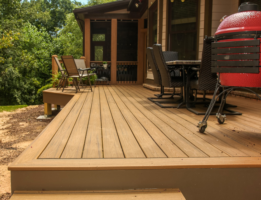 This is an example of a large traditional backyard deck in Atlanta with with fireplace and a roof extension.