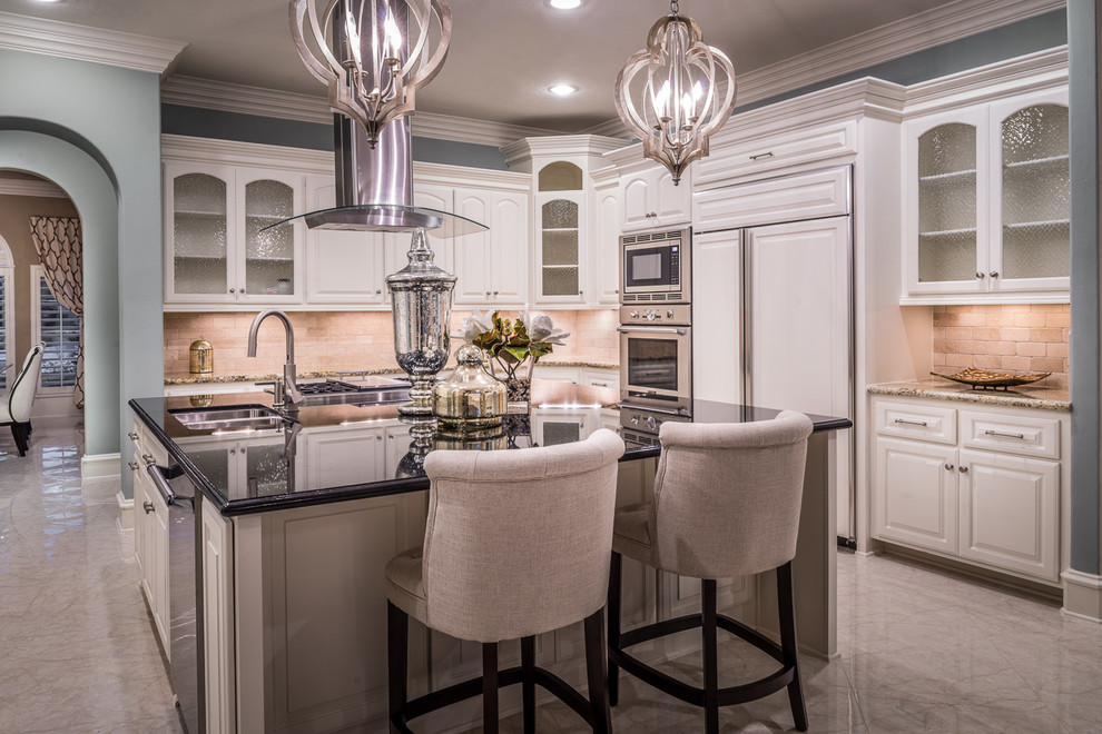 Design ideas for a mid-sized transitional eat-in kitchen in Houston with an undermount sink, glass-front cabinets, beige splashback, stainless steel appliances and marble floors.