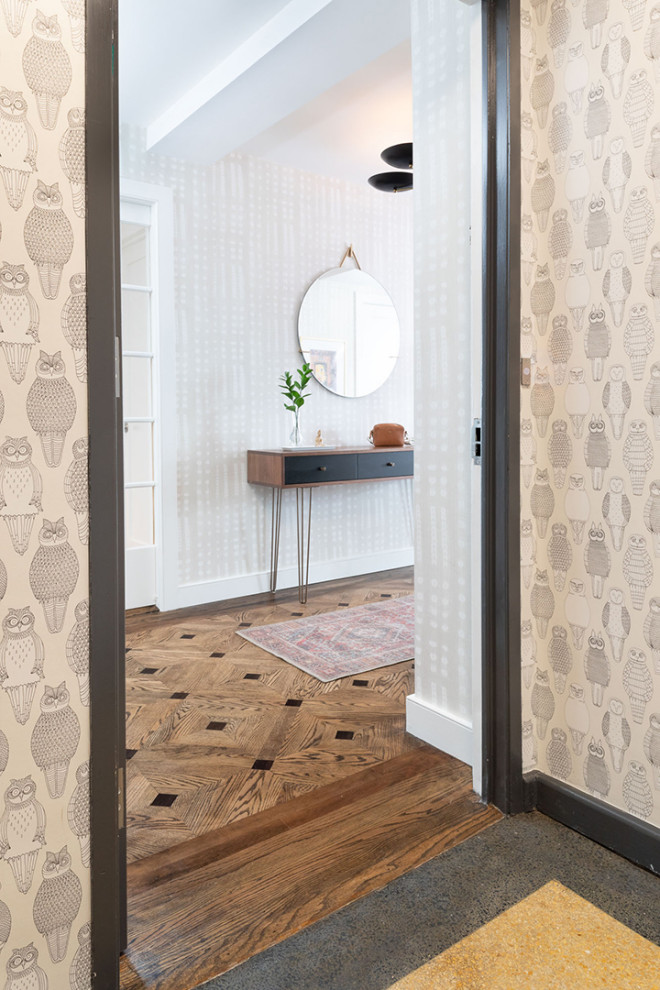 Design ideas for a small transitional foyer in New York with grey walls, medium hardwood floors, grey floor and wallpaper.