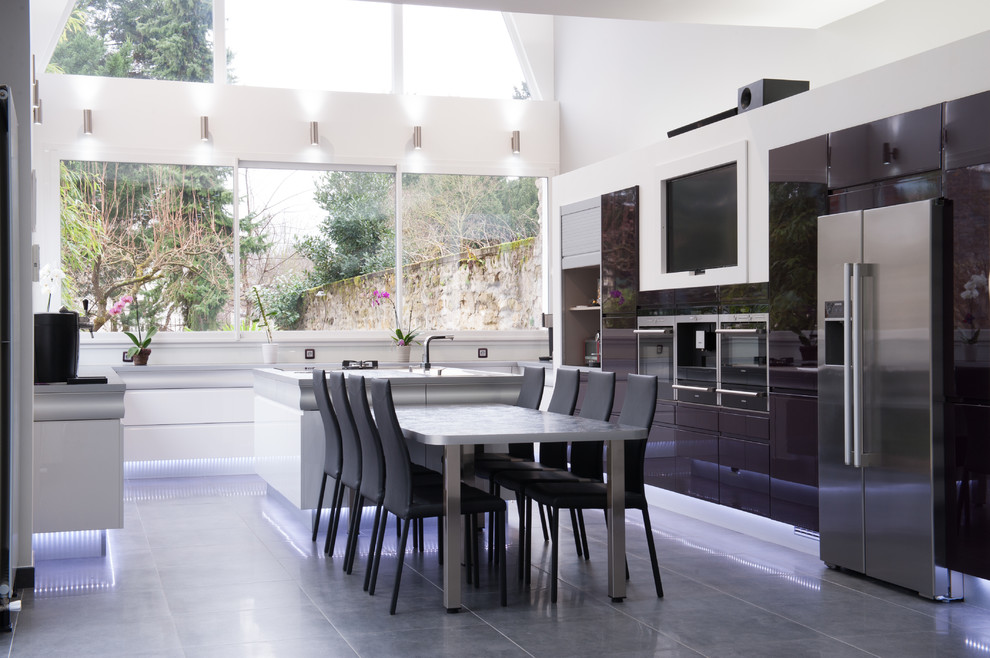 Photo of a large contemporary u-shaped open plan kitchen in Nantes with white splashback, stainless steel appliances, with island and black cabinets.
