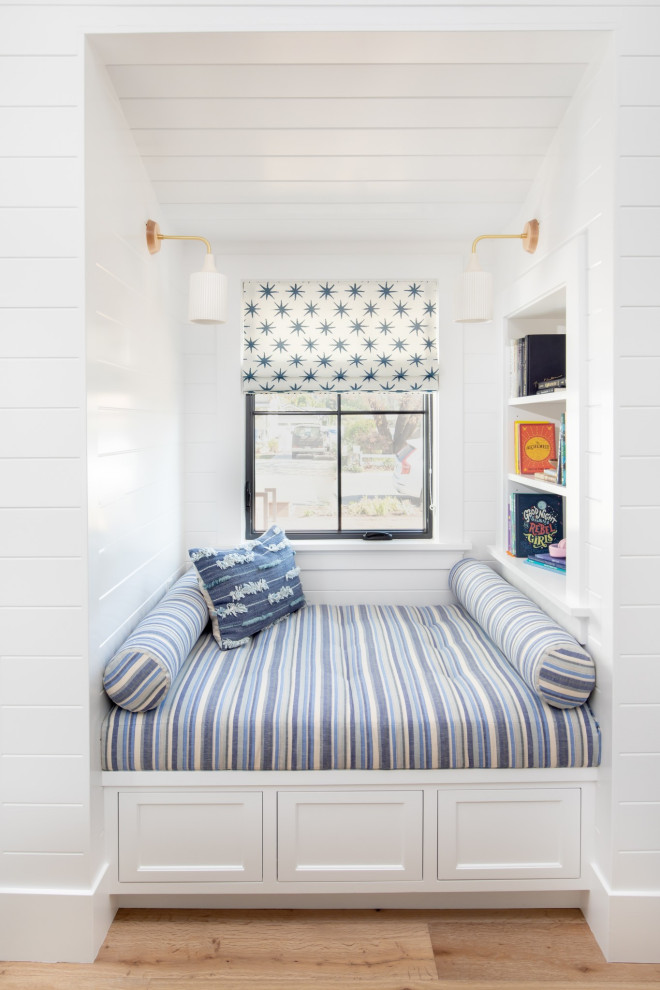 North Tustin - Addition and Remodel - Here's a charming built-in reading nook with built-in shelves and custom lower cabinet drawers underneath the bench. Shiplap covered walls and ceiling with recessed light fixture and sconce lights for an ideal reading and relaxing space.

Photo by Molly Rose Photography