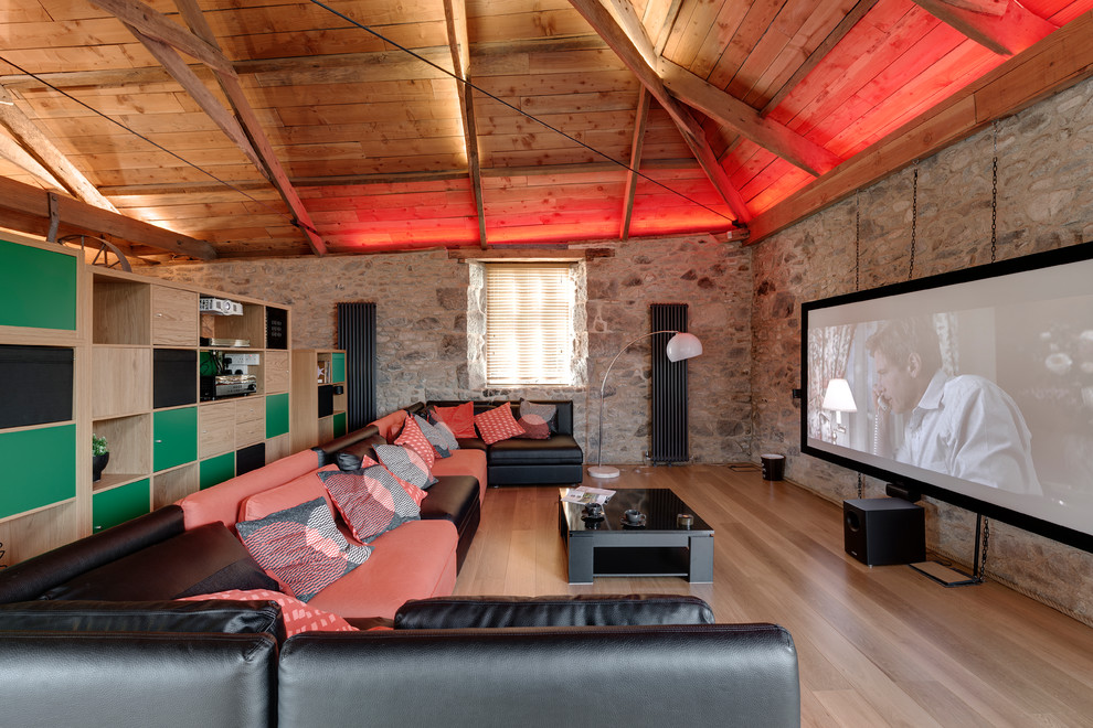Expansive country open concept home theatre in Devon with a projector screen and brown floor.