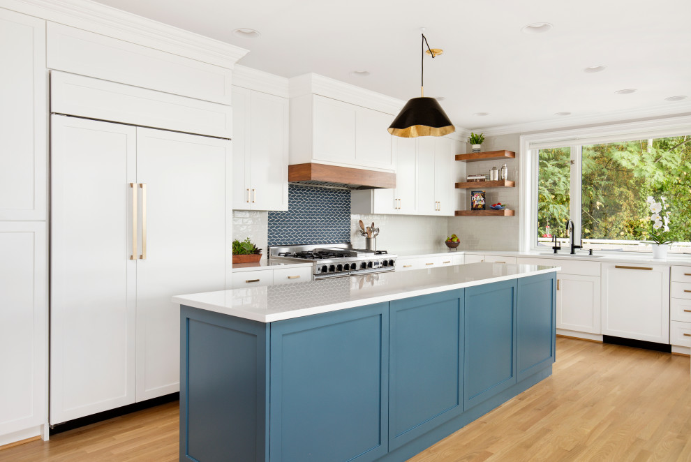 Design ideas for a contemporary kitchen in Portland with an undermount sink, shaker cabinets, white cabinets, quartz benchtops, white splashback, glass tile splashback, panelled appliances, light hardwood floors, with island, brown floor and white benchtop.
