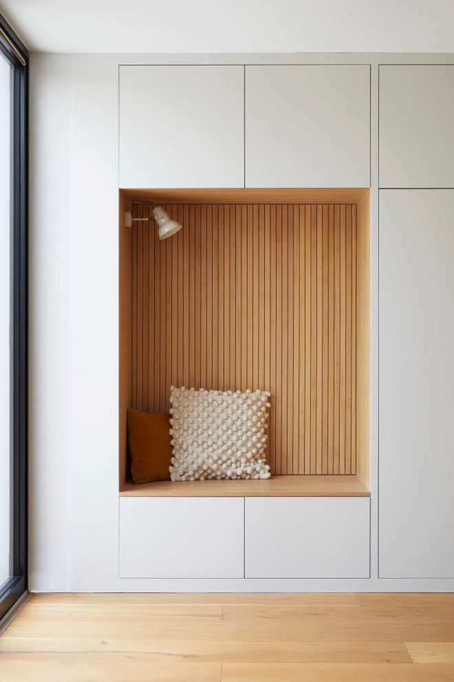 Foto di un grande soggiorno minimal aperto con pareti grigie, pavimento in legno massello medio e pannellatura