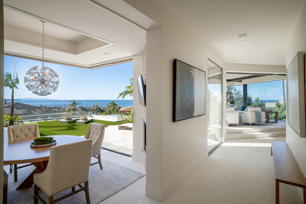 Photo of an expansive contemporary hallway in San Diego with white walls, limestone floors and white floor.