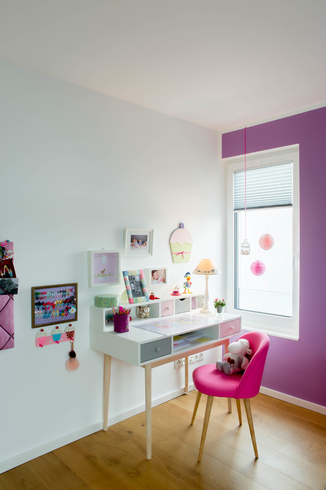 Mädchenzimmer mit Arbeitsecke, lila Wandfarbe und hellem Holzboden in Dusseldorf
