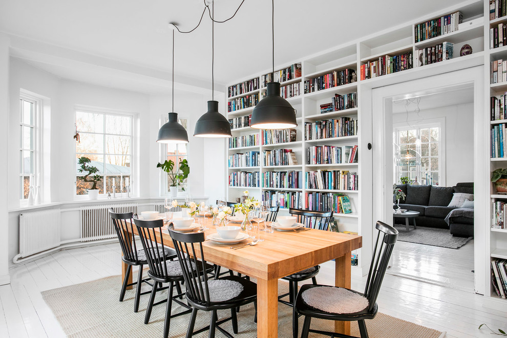 This is an example of a mid-sized scandinavian separate dining room in Malmo with white walls and painted wood floors.