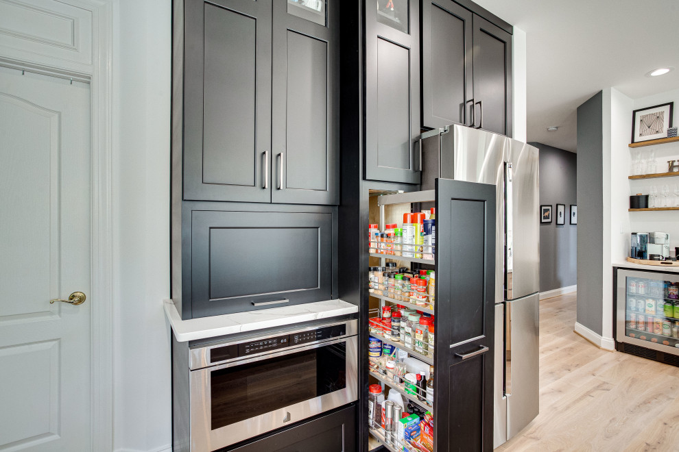 Large transitional u-shaped eat-in kitchen photo in DC Metro with a farmhouse sink, quartz countertops, stainless steel appliances and an island