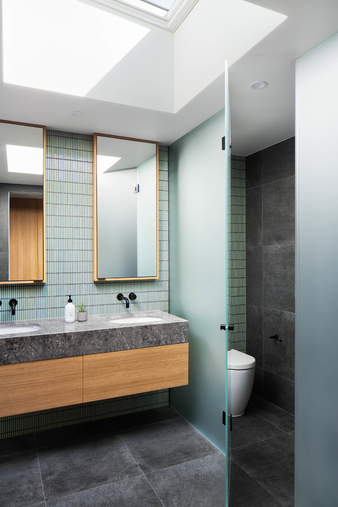 Mid-sized contemporary master bathroom in Melbourne with flat-panel cabinets, white cabinets, a drop-in tub, a corner shower, a two-piece toilet, black and white tile, gray tile, ceramic tile, grey walls, ceramic floors, a drop-in sink, engineered quartz benchtops, grey floor, a hinged shower door and white benchtops.