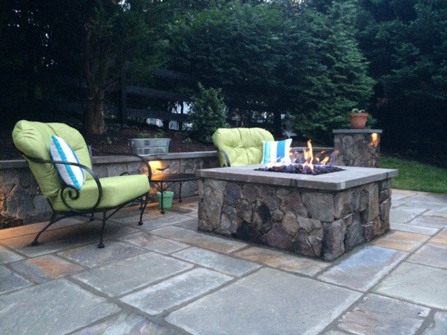 Photo of a mid-sized traditional backyard patio in Other with a fire feature and natural stone pavers.