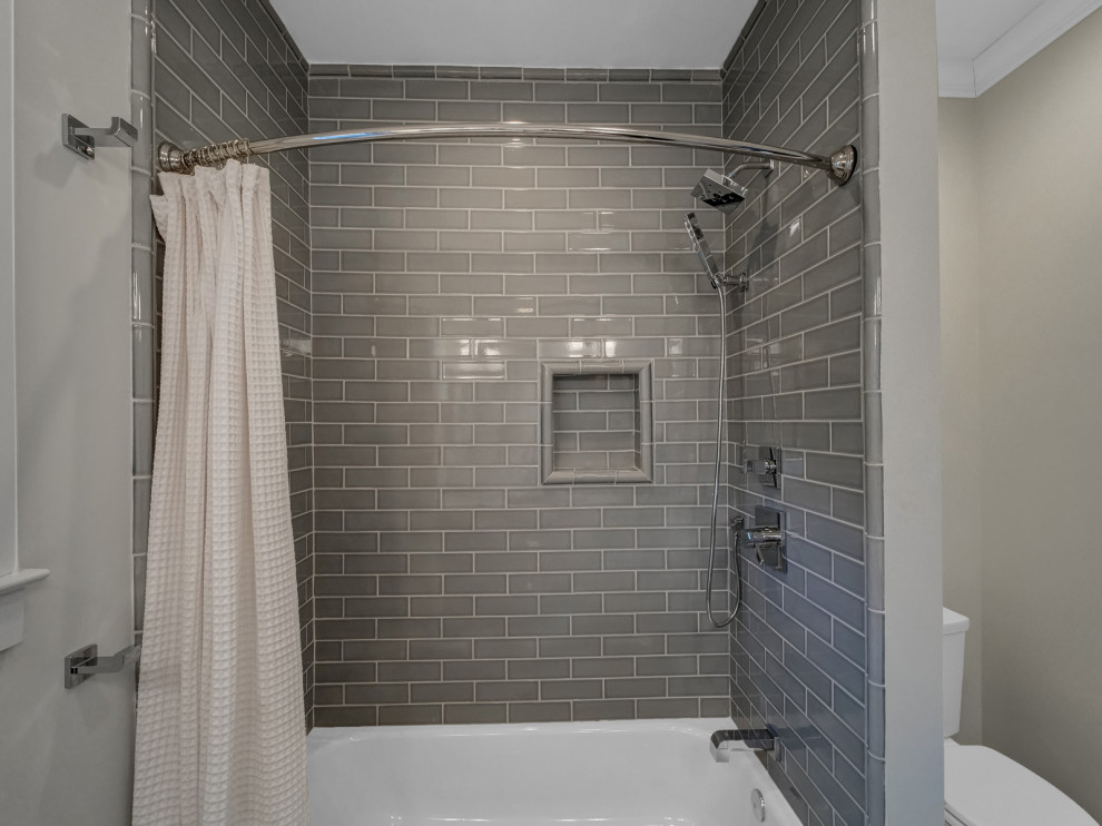 Design ideas for a mid-sized transitional kids bathroom in New York with shaker cabinets, grey cabinets, an alcove tub, an alcove shower, a two-piece toilet, gray tile, porcelain tile, grey walls, marble floors, an undermount sink, engineered quartz benchtops, white floor, a shower curtain, white benchtops, a niche, a single vanity and a built-in vanity.