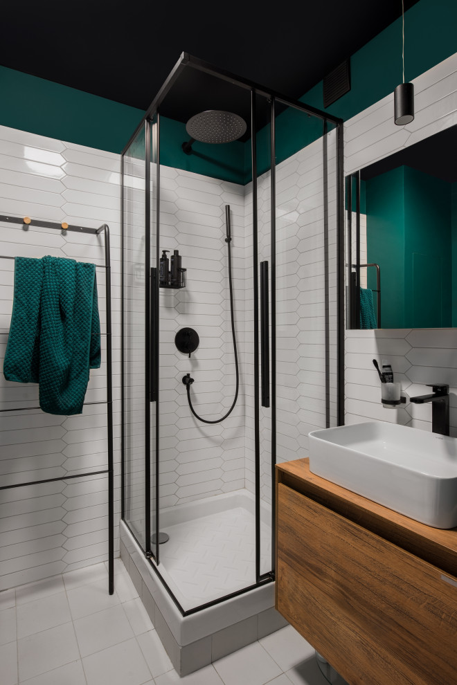 Idéer för att renovera ett litet funkis badrum med dusch, med släta luckor, skåp i mellenmörkt trä, en hörndusch, en vägghängd toalettstol, vit kakel, keramikplattor, gröna väggar, klinkergolv i porslin, ett nedsänkt handfat, träbänkskiva, grått golv och dusch med duschdraperi