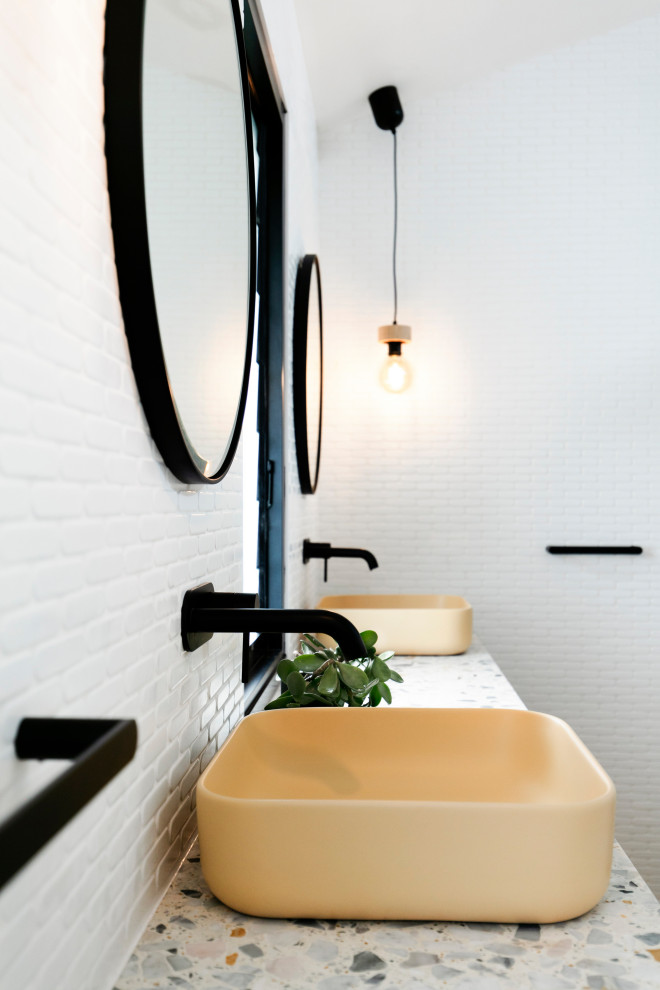Пример оригинального дизайна: детская ванная комната среднего размера в морском стиле с белыми фасадами, накладной ванной, душем над ванной, раздельным унитазом, белой плиткой, керамической плиткой, белыми стенами, полом из керамической плитки, настольной раковиной, столешницей терраццо, коричневым полом, открытым душем, разноцветной столешницей, сиденьем для душа, тумбой под две раковины, подвесной тумбой и сводчатым потолком