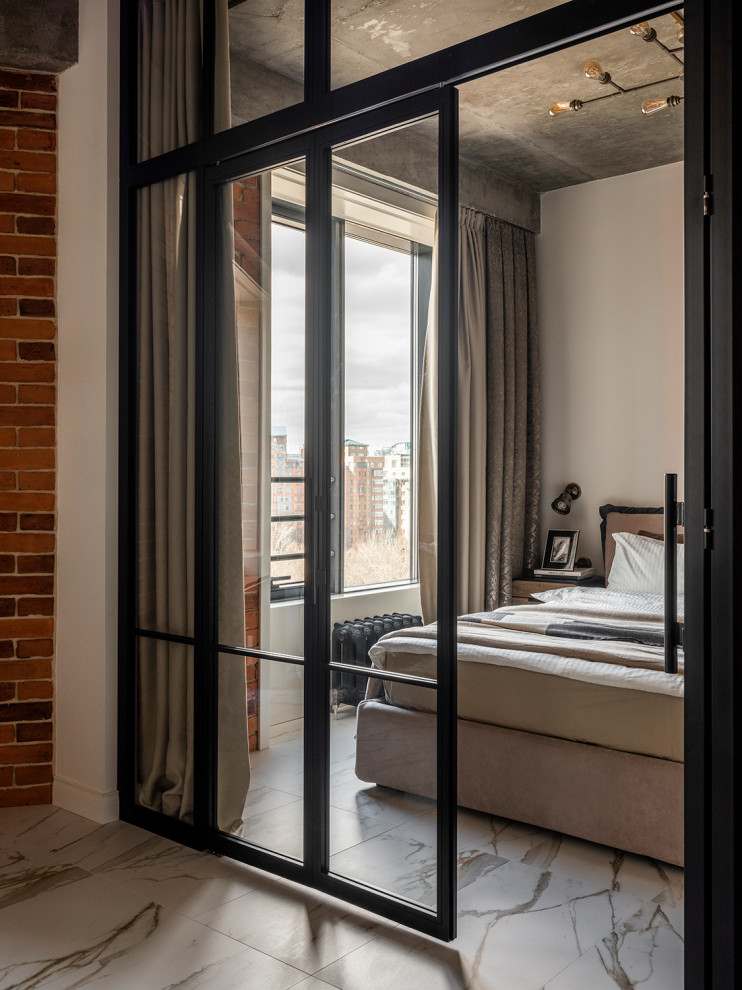 This is an example of an industrial bedroom in Moscow with grey walls, white floor and brick walls.