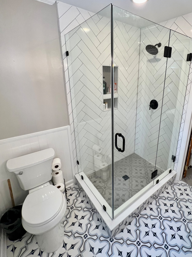 Inspiration for a medium sized contemporary ensuite bathroom in Raleigh with a corner shower, grey walls, ceramic flooring, multi-coloured floors, a hinged door, a wall niche and a freestanding vanity unit.