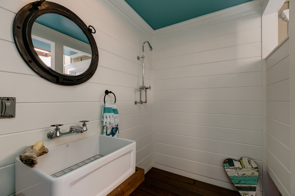 Inspiration for a mid-sized beach style wet room bathroom in Los Angeles with shaker cabinets, white cabinets, white tile, white walls, medium hardwood floors, a console sink, beige floor and an open shower.