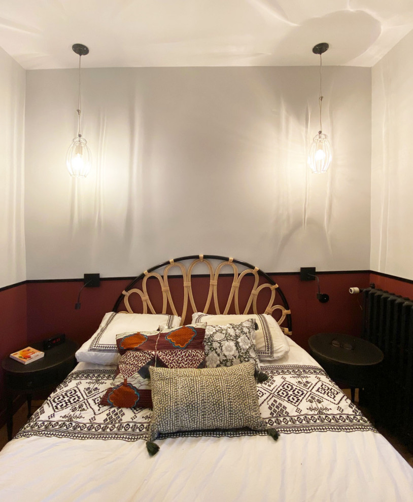 Diseño de dormitorio bohemio de tamaño medio con paredes rojas y suelo de madera clara