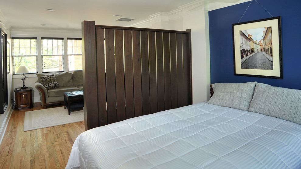 Inspiration for a traditional loft-style bedroom in Atlanta with blue walls and light hardwood floors.
