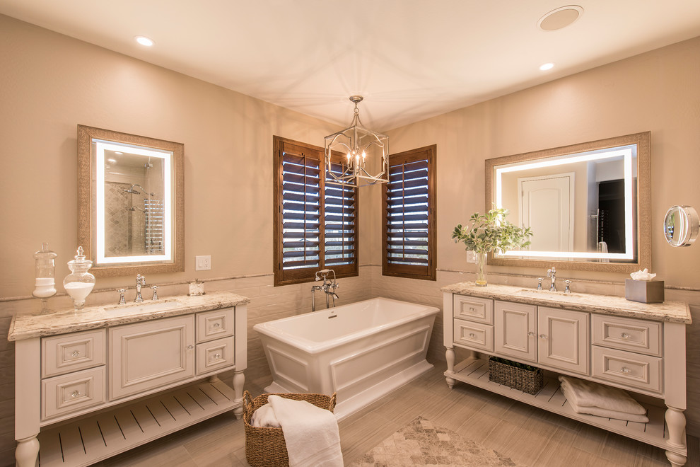 Inspiration for a large traditional master bathroom in Phoenix with furniture-like cabinets, white cabinets, a freestanding tub, an alcove shower, beige tile, porcelain tile and engineered quartz benchtops.