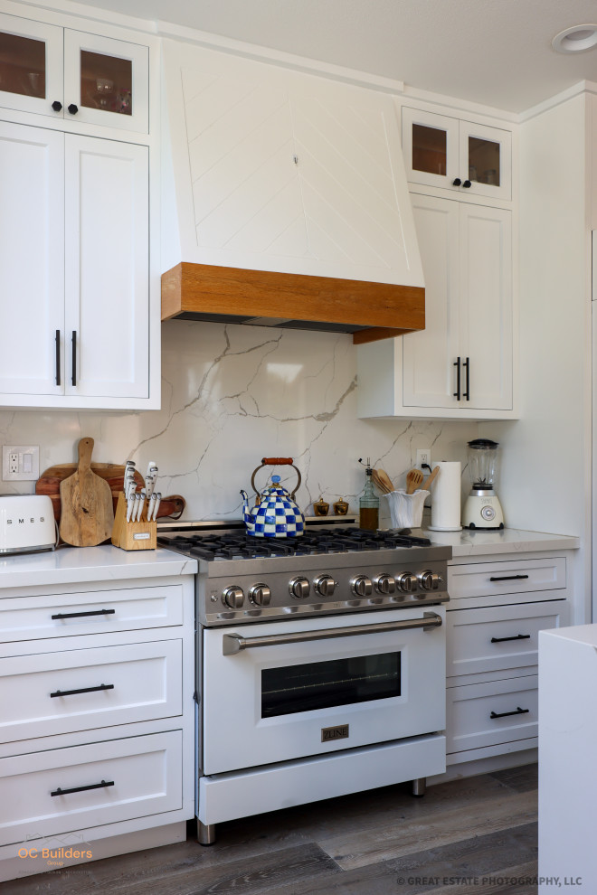 Exempel på ett mycket stort medelhavsstil flerfärgad flerfärgat kök, med en rustik diskho, luckor med infälld panel, vita skåp, marmorbänkskiva, vitt stänkskydd, stänkskydd i marmor, vita vitvaror, ljust trägolv, en köksö och beiget golv