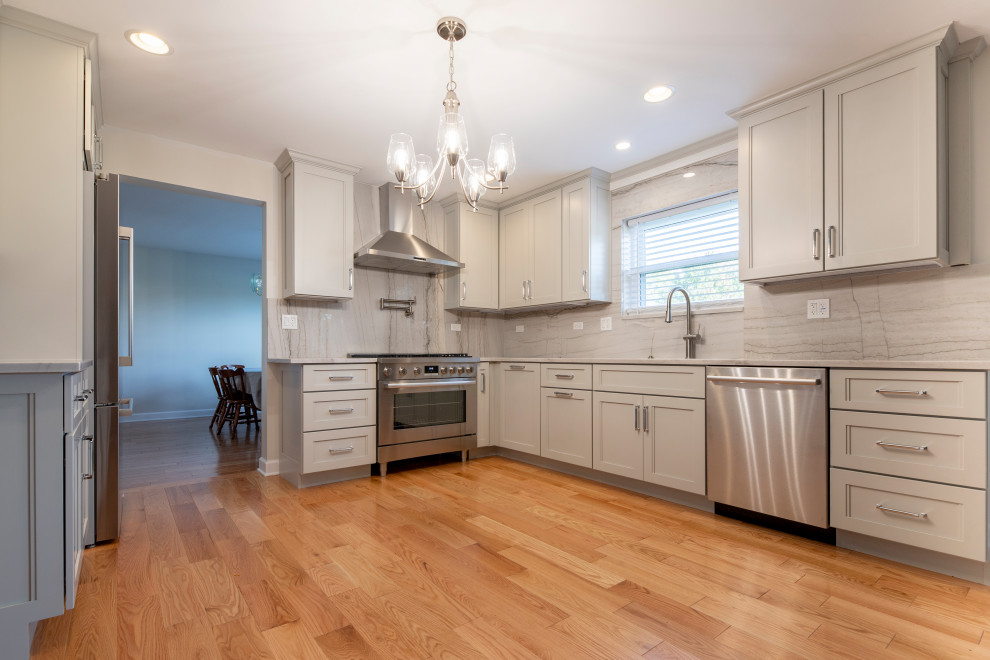 Exempel på ett mellanstort klassiskt grå grått kök, med en nedsänkt diskho, luckor med profilerade fronter, grå skåp, bänkskiva i kvarts, grått stänkskydd, rostfria vitvaror, korkgolv och gult golv