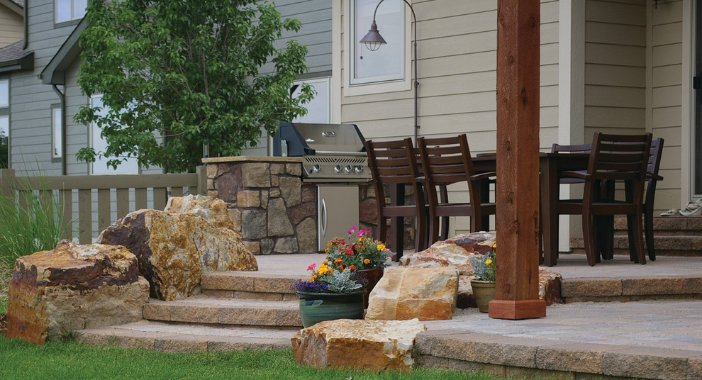 Photo of a mid-sized backyard concrete paver landscaping in Denver with a fire pit.