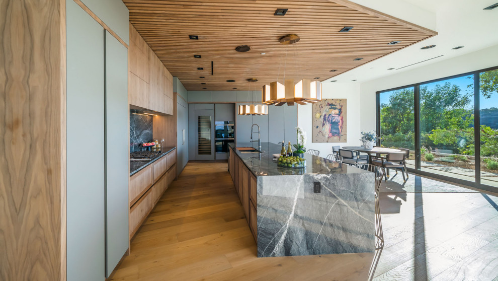 Geräumige Moderne Küche in L-Form mit Doppelwaschbecken, hellen Holzschränken, Marmor-Arbeitsplatte und Kücheninsel in Los Angeles
