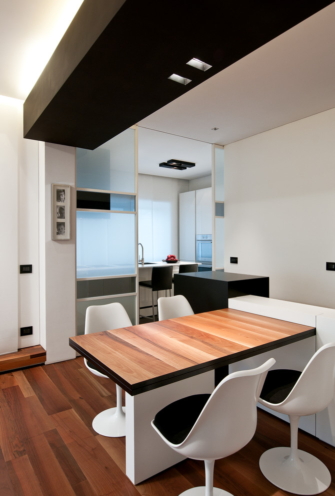 Small contemporary open plan dining in Rome with white walls, dark hardwood floors, no fireplace and brown floor.