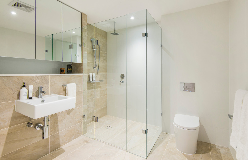 This is an example of a small contemporary 3/4 bathroom in Sydney with a corner shower, a one-piece toilet, beige tile, marble, white walls, marble floors, a wall-mount sink, beige floor, a hinged shower door and flat-panel cabinets.