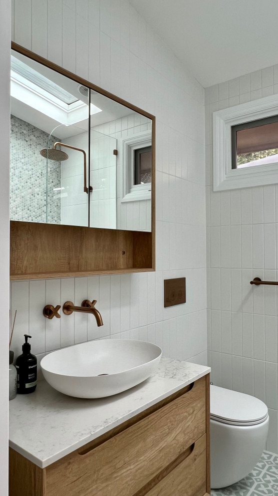 Свежая идея для дизайна: маленькая главная ванная комната в современном стиле с фасадами островного типа, коричневыми фасадами, угловой ванной, душем над ванной, инсталляцией, белой плиткой, керамической плиткой, белыми стенами, полом из керамической плитки, консольной раковиной, столешницей из искусственного кварца, зеленым полом, открытым душем, белой столешницей, тумбой под одну раковину и подвесной тумбой для на участке и в саду - отличное фото интерьера