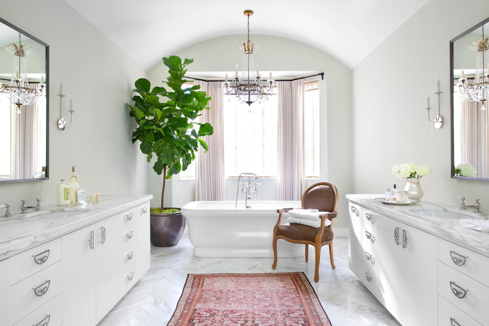 Inspiration for a transitional bathroom in Los Angeles with an undermount sink, flat-panel cabinets, white cabinets, marble benchtops, a freestanding tub, marble floors and grey walls.