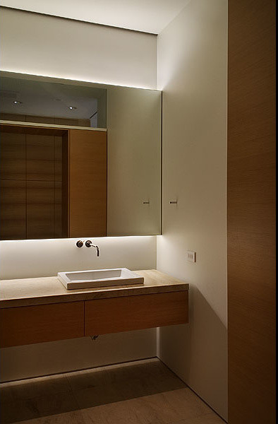 Bathroom - modern master limestone floor bathroom idea in Houston with a drop-in sink, open cabinets, medium tone wood cabinets, limestone countertops, a one-piece toilet and white walls
