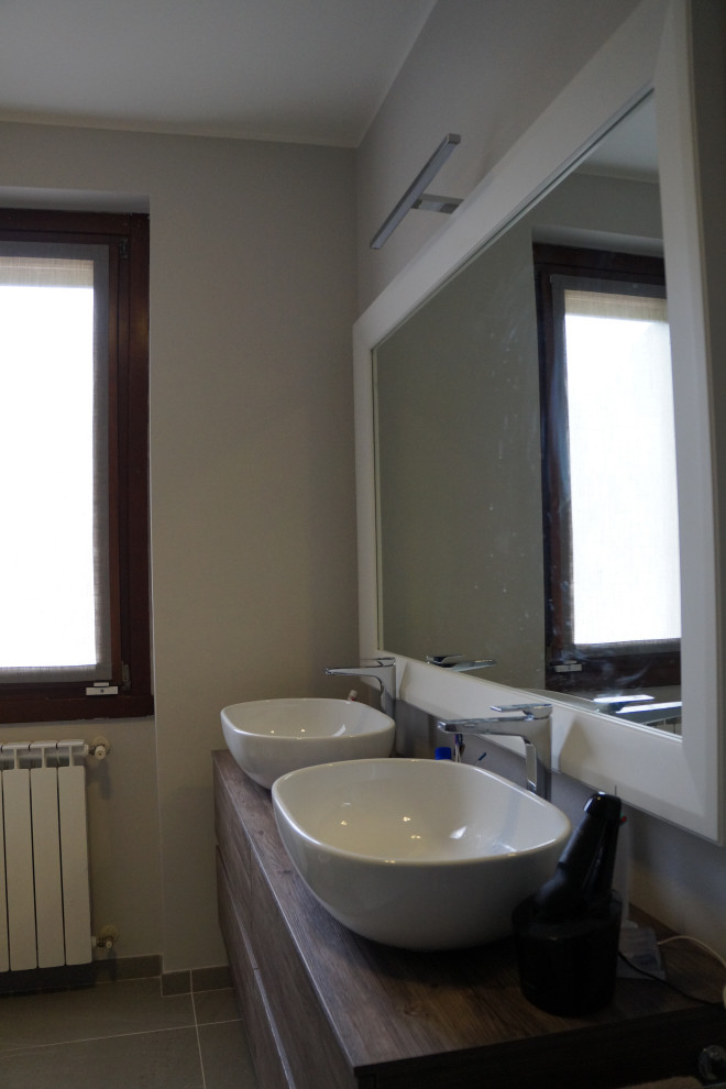 Idéer för ett mellanstort modernt brun toalett, med släta luckor, skåp i mörkt trä, en vägghängd toalettstol, vit kakel, porslinskakel, vita väggar, tegelgolv, ett fristående handfat, laminatbänkskiva och rött golv