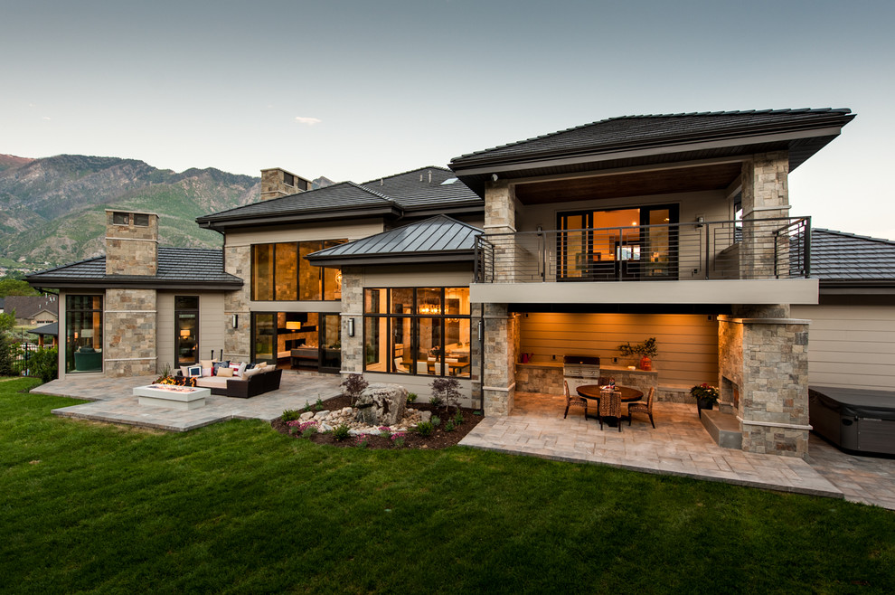 Photo of a mid-sized transitional two-storey brown exterior in Salt Lake City with stone veneer and a hip roof.