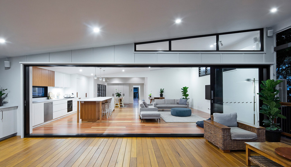 Mid-sized beach style backyard deck in Brisbane with an outdoor kitchen and a roof extension.